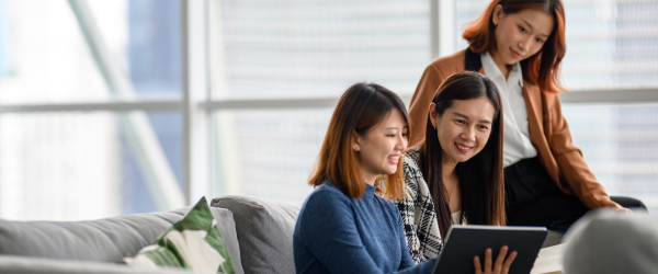 people smiling and looking at tablet