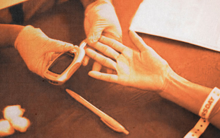 Doctor taking diabetic patient's glucose reading