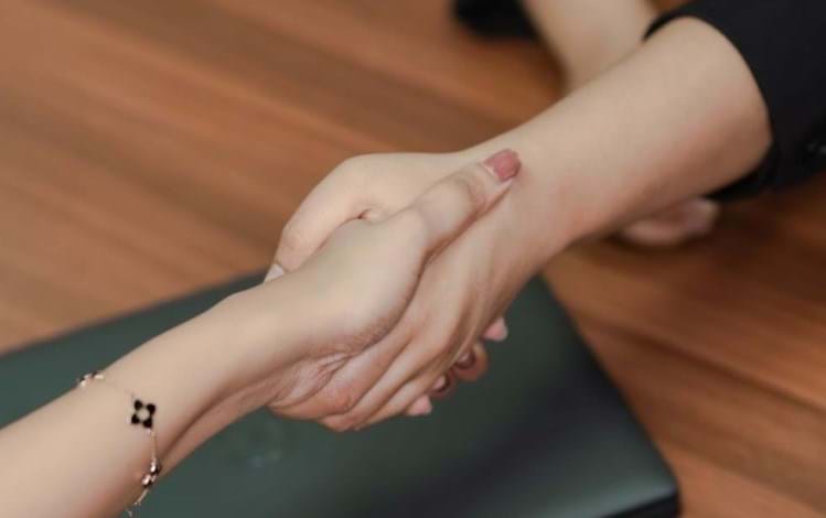 Two people shaking hands over a desk