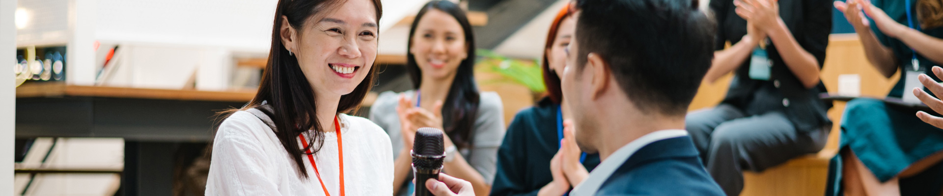 Leaders speaking with microphone in front of an audience